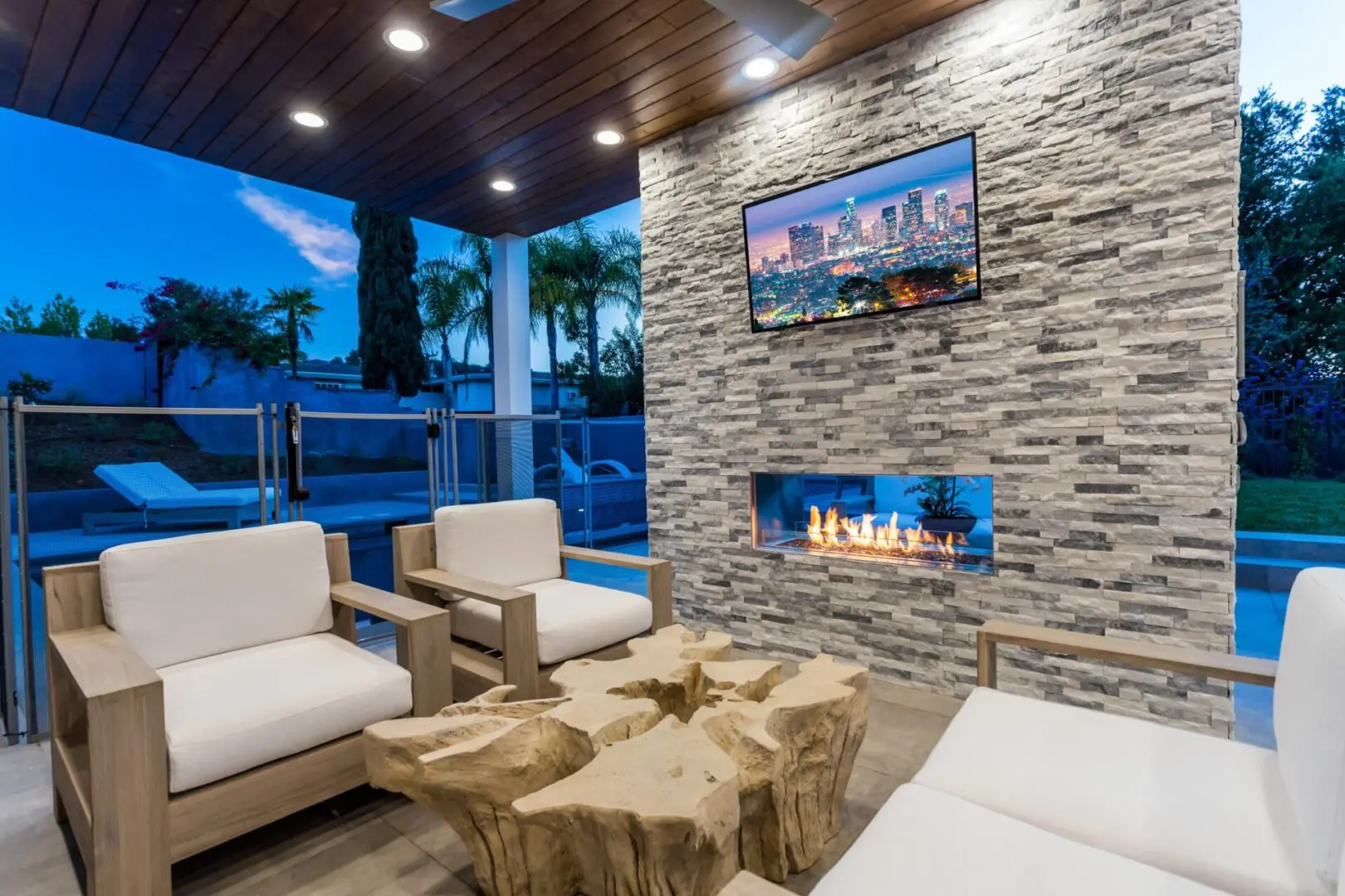 outdoor entertainment with fireplace and TV at night